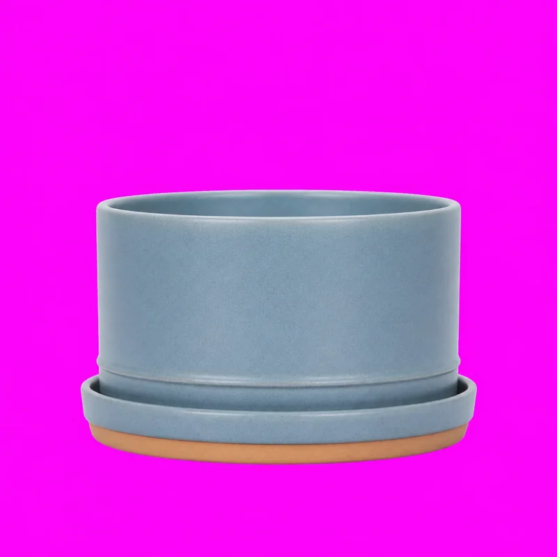 Fictional mineral-blue ceramic planter and saucer centered on a flat magenta removal background